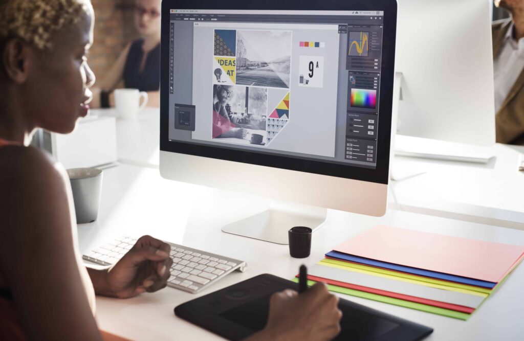 Woman designing a booklet on a laptop using Photoshop