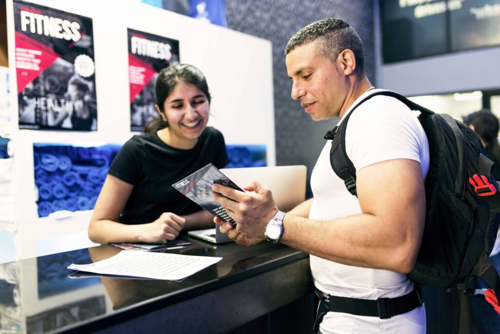 Gym employee reviewing a printed brochure with a potential customer