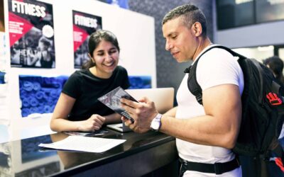 Gym employee reviewing a printed brochure with a potential customer