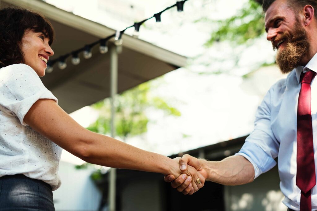 Two business people shaking hands outside