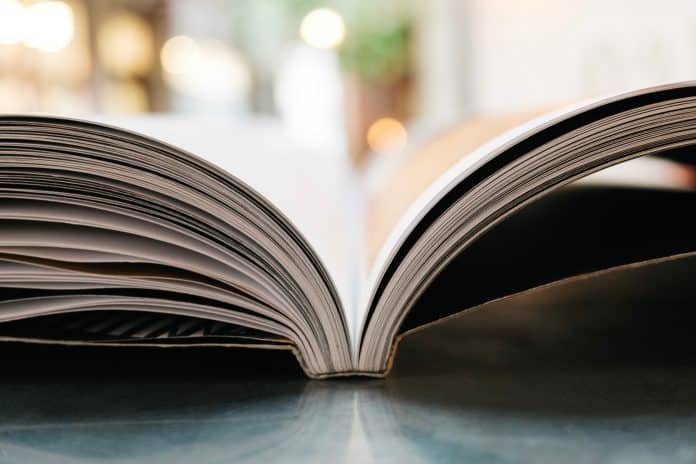 A close up of the spine of a large page count PUR perfect bound book opened.