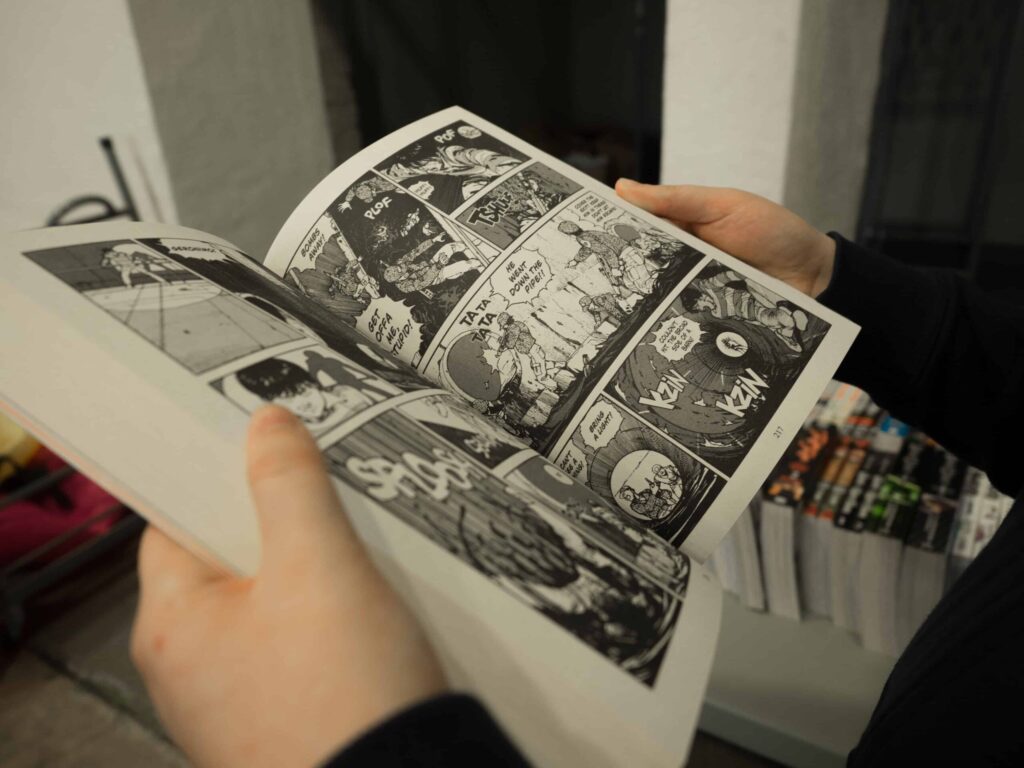 Man holding a black and white comic book