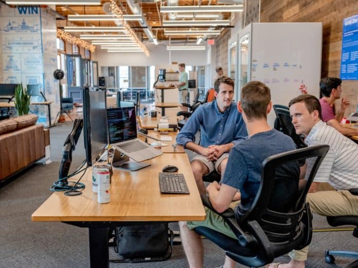 Employees in an open space office discussing work