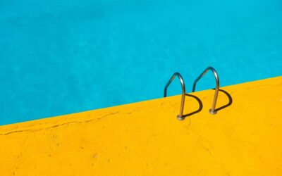 A picture of a pool and ground with the color combination of blue and yellow