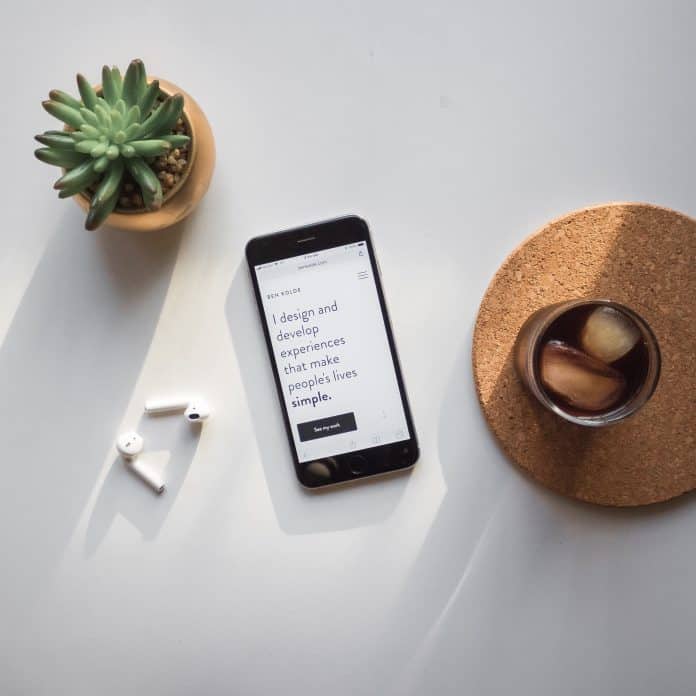 A phone, drink, and plant on a white background