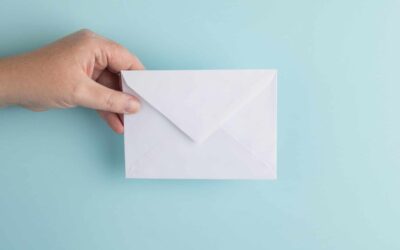 hand holding an envelope over blue background