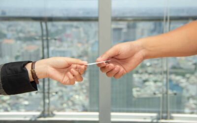 close-up of hands handing off a business card