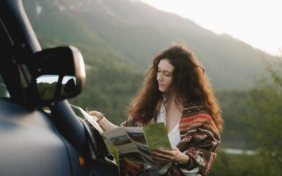 Person looking at a travel brochure by the mountains