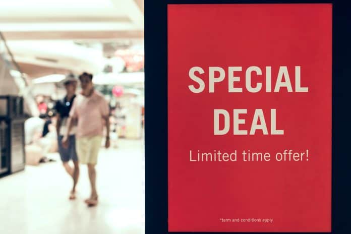 man walking inside mall and sign for scarcity marketing