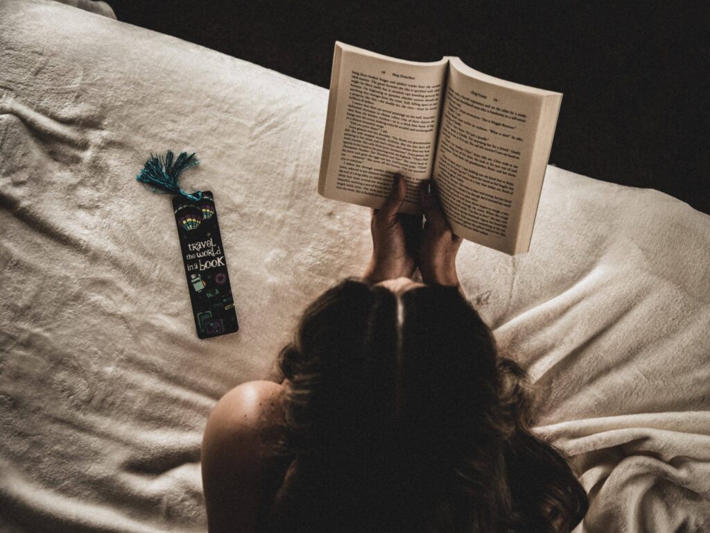 Person reading a book with a custom bookmark text to them