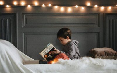 Child holding a childrens book cover idea book on a white surface